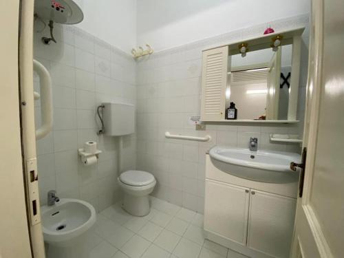uma casa de banho branca com um lavatório e um WC em Nonna Rosetta Traditional Studio em Vernazza