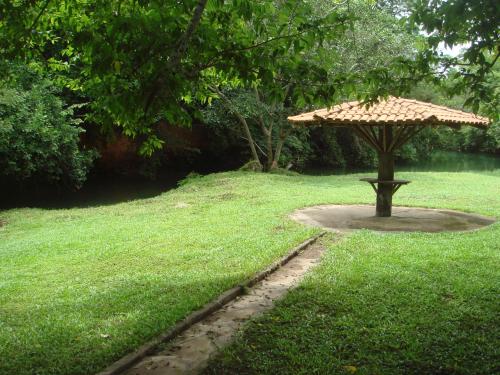 a umbrella sitting in the middle of a grass field at Sítio Chalako, casa exclusiva às margens do Rio Mimoso in Bonito