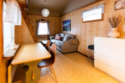 a living room with a table and a couch at Aurora River Camp Glass igloos & cabins in Kiruna