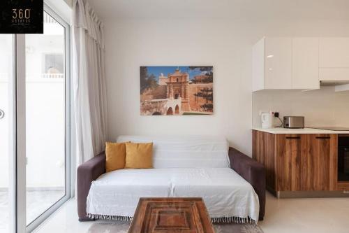 Sala de estar con cama y mesa de centro en Comfy APT with Terrace, 5 mins to Sliema Ferries by 360 Estates, en Il-Gżira