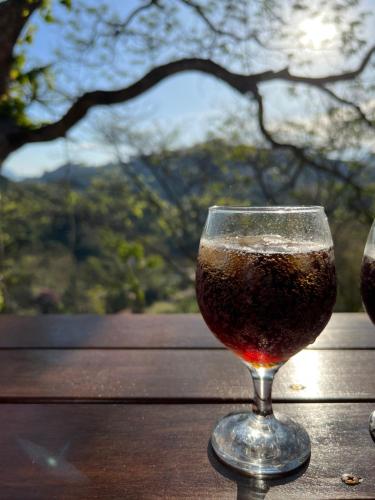 a glass of wine sitting on a table at Casa do Alto Santa Mônica- Natureza ao seu redor in Itaipava