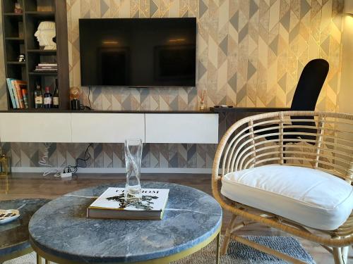 a living room with a table and a chair and a tv at Negotin Centar Apartment with Parking in Negotin