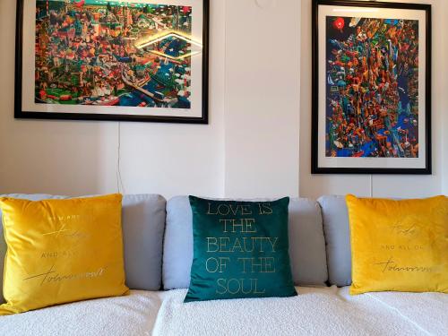 un divano con 2 cuscini gialli e un quadro di Negotin Centar Apartment with Parking a Negotin