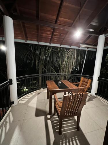 a patio with two chairs and a table on a balcony at Tanzanite place in Tangalle