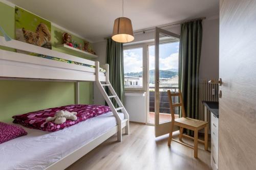 een kleine slaapkamer met een stapelbed en een balkon bij Casa Waldheim in Brunico