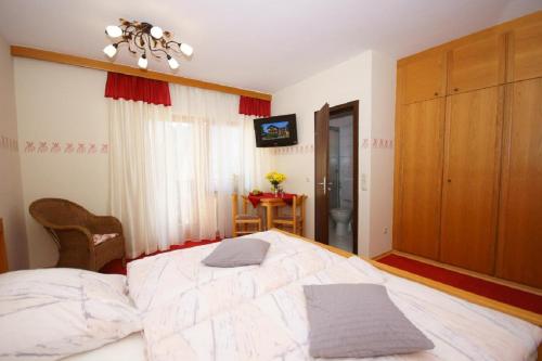 Schlafzimmer mit einem großen weißen Bett in der Unterkunft Landhotel Neuhof in Zenting