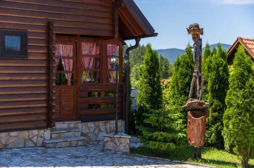 a wooden cabin with a porch and a wooden door at Zlatibor Brvnare Zakos in Zlatibor