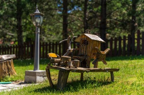 a statue of a bird house on a park bench at Zlatibor Brvnare Zakos in Zlatibor