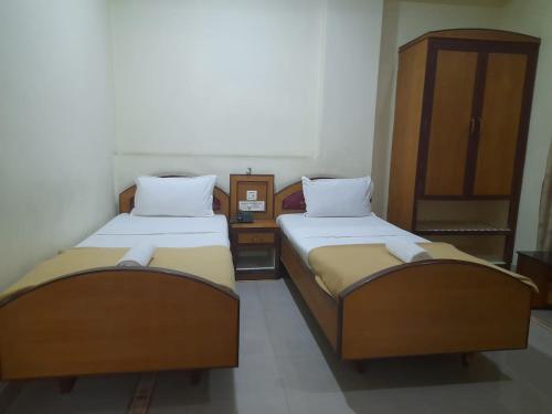 2 camas individuales en una habitación con armario en DP OBEROI RESIDENCY, en Ernakulam