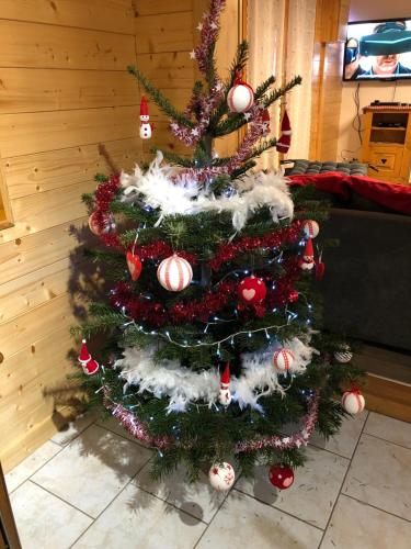 a christmas tree with ornaments on it in a room at Chalet O FIL DE LO - wifi, BBQ, parking in Xonrupt-Longemer