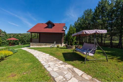 a yard with a chair and a house at Zlatibor Brvnare Zakos in Zlatibor