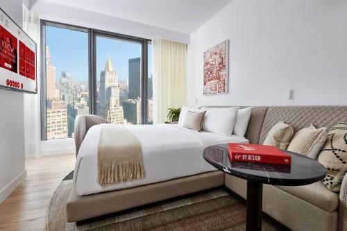 a bedroom with a bed and a couch and a window at Virgin Hotels New York City in New York