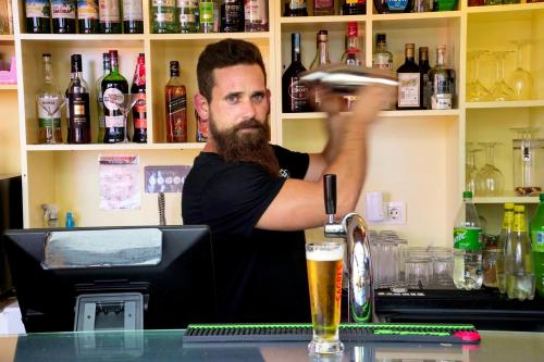 a man sitting at a bar with a glass of beer at Pátio Ecolodge in Cedros