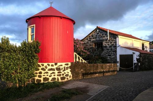 a red tower next to a building with a house at Pátio Ecolodge in Cedros