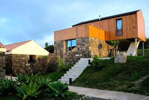 a house with a stone wall and stairs at Pátio Ecolodge in Cedros