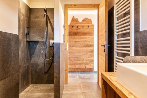 uma casa de banho com um chuveiro e um lavatório. em Zu Grof Morgenrot em Castelrotto