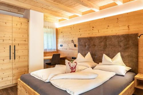 1 dormitorio con 1 cama grande con almohadas blancas en Zu Grof Morgenrot en Castelrotto
