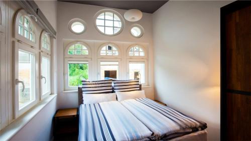 a bedroom with a bed with four windows at Parkresidenz Lychen, Ferienwohnung 8 in Lychen