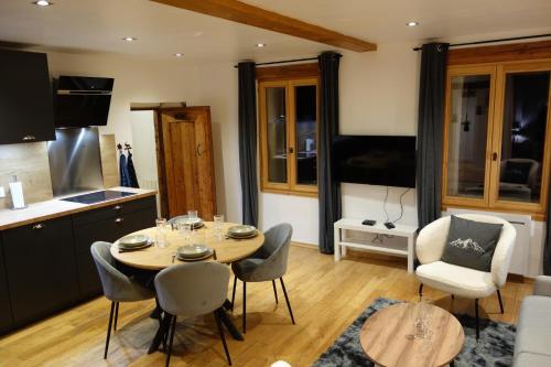une cuisine et une salle à manger avec une table et des chaises dans l'établissement Chez petit Louis- Appart centre ville jusqu'à 6 personnes, à Briançon