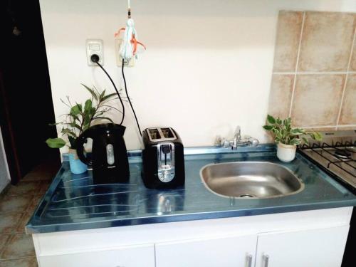 a kitchen counter top with a sink and a sink at Buenos Aires Tango Apartment near Golf in San Antonio de Padua