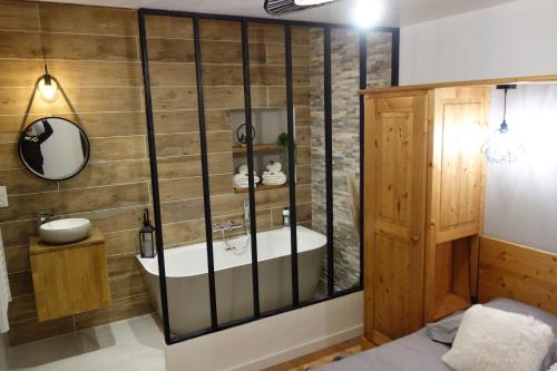 a bathroom with a tub and a sink at Chez petit Louis- Appart centre ville jusqu'à 6 personnes in Briançon