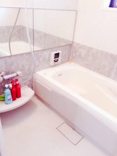 a bathroom with a white tub and a white sink at 大阪ウェンシン民泊 in Osaka