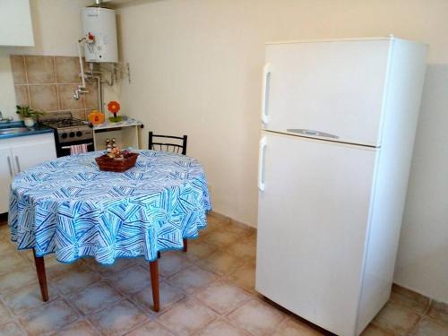 a kitchen with a table and a white refrigerator at Buenos Aires Tango Apartment near Golf in San Antonio de Padua