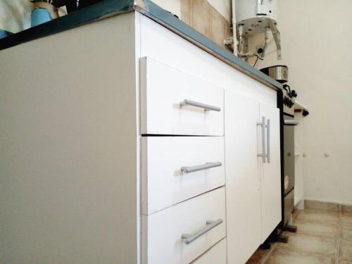 a white cabinet with drawers in a room at Buenos Aires Tango Apartment near Golf in San Antonio de Padua