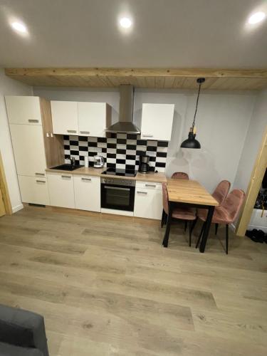 een keuken met witte kasten en een houten tafel bij Jagiellońska 7a/1 in Zakopane