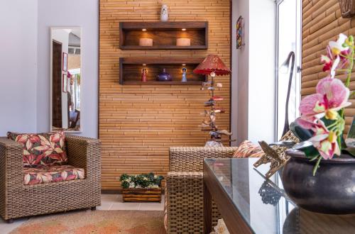 a living room with a chair and a table at Ciribaí Praia Hotel in Pauba