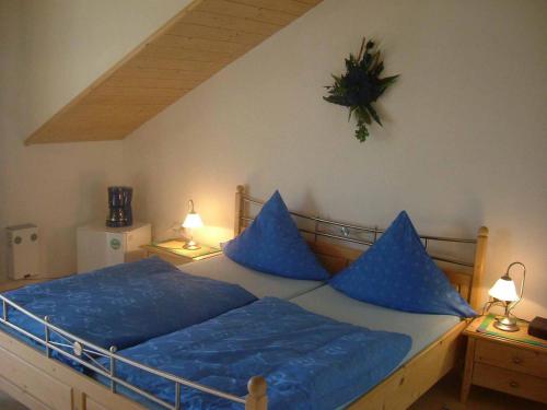 a bedroom with a bed with blue pillows on it at Ferienhaus Corinna in Kirchdorf im Wald