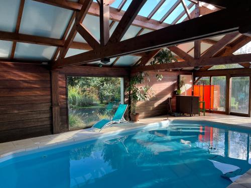 Maison avec piscine et sauna à Vire في فير: مسبح في بيت بسقف