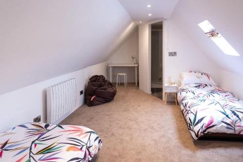 a attic room with a bed and a staircase at WOOLACOMBE OAKLEA 4 Bedrooms in Woolacombe