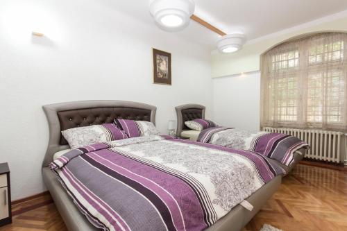 Un dormitorio con dos camas y una ventana. en Bukoleon Apartment, en Belgrado