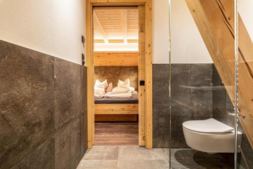 a bathroom with a toilet and a bunk bed at Zu Grof Alpenglühn in Castelrotto