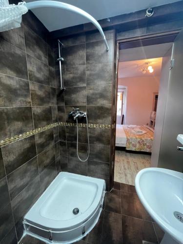 La salle de bains est pourvue d'une douche, d'un lavabo et d'une baignoire. dans l'établissement Guesthouse Athos, à Kotor