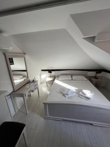 - une chambre avec un lit blanc et un miroir dans l'établissement Guesthouse Athos, à Kotor