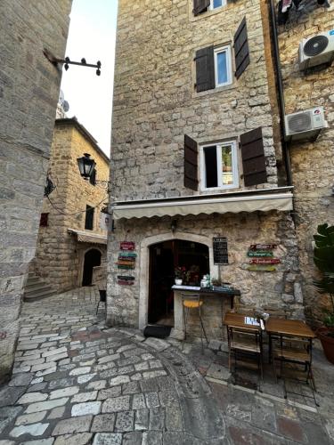 a stone building with a table in front of it at Athos Guesthouse in Kotor