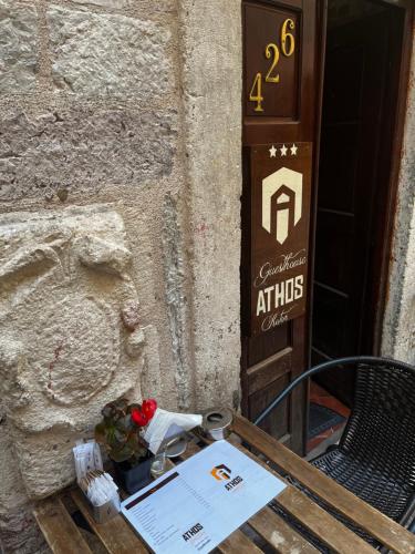 a table with flowers and a sign in front of a building at Athos Guesthouse in Kotor