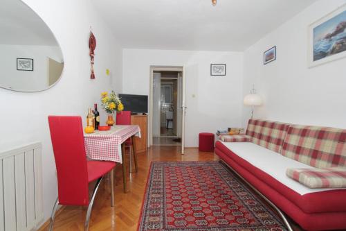 a living room with a red couch and a table at Apartment Nane in Dubrovnik