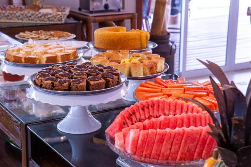 a buffet filled with different types of cakes and pies at Ciribaí Praia Hotel in Pauba