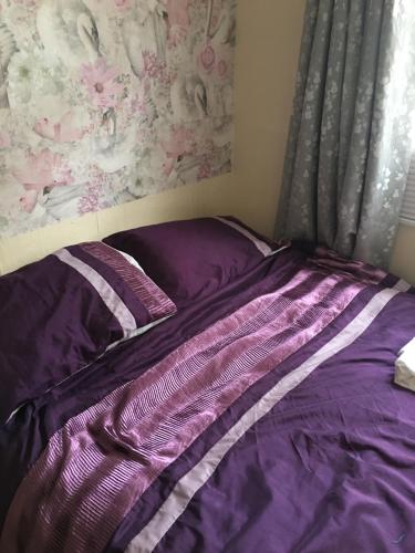 達特茅斯的住宿－Seaside Serenity，卧室内的一张带紫色棉被的床
