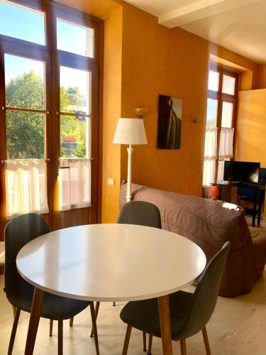 un salon avec une table, des chaises et un canapé dans l'établissement T2 avec terrasse vue Hautacam dans villa historique 