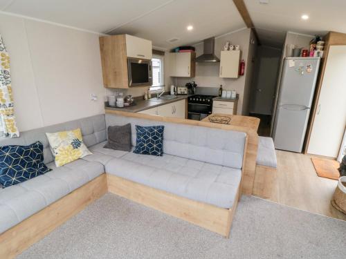 a living room with a couch and a kitchen at Pines 30 in Scarborough