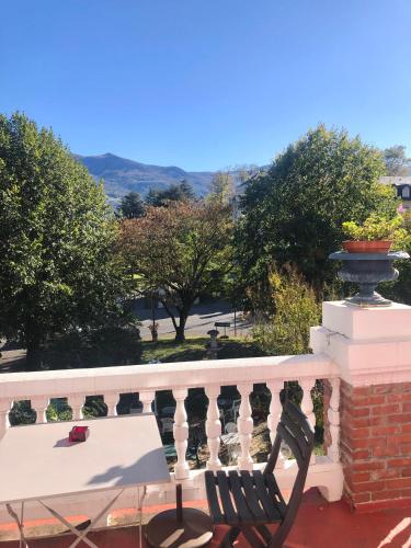 un banco sentado en un balcón con vistas en T2 avec terrasse vue Hautacam dans villa historique "Victoria", en Argelès-Gazost