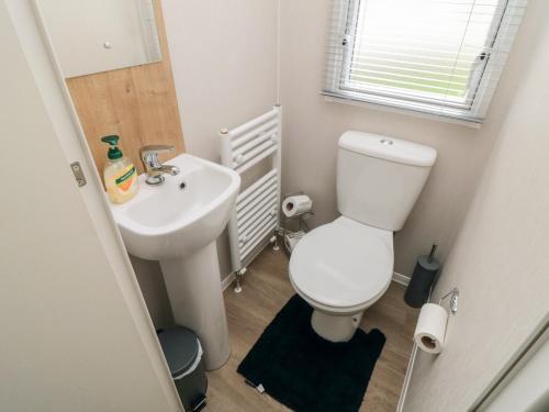 a small bathroom with a toilet and a sink at Pines 30 in Scarborough