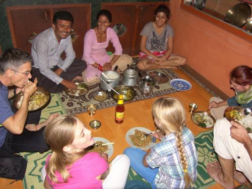 a group of people sitting on the floor eating food at Rupa View Guest house in Pokhara