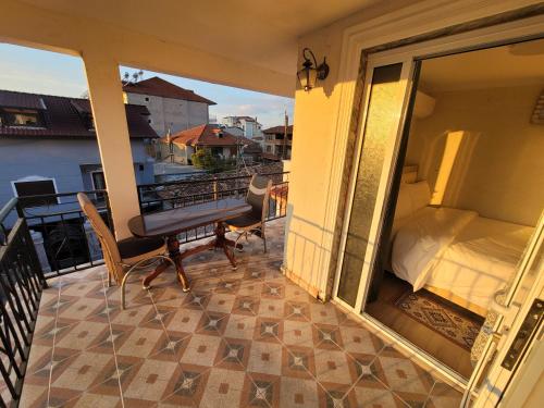 einen Balkon mit einem Bett und einem Tisch auf dem Balkon in der Unterkunft Vila Lika in Korçë