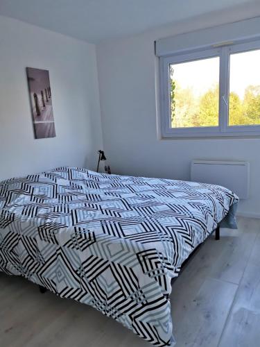 une chambre avec un lit avec une couette noire et blanche dans l'établissement Le Mabileau, à Saumur