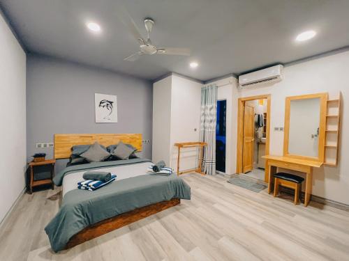 una camera con letto e ventilatore a soffitto di Mahchavaru Maldives a Mathiveri